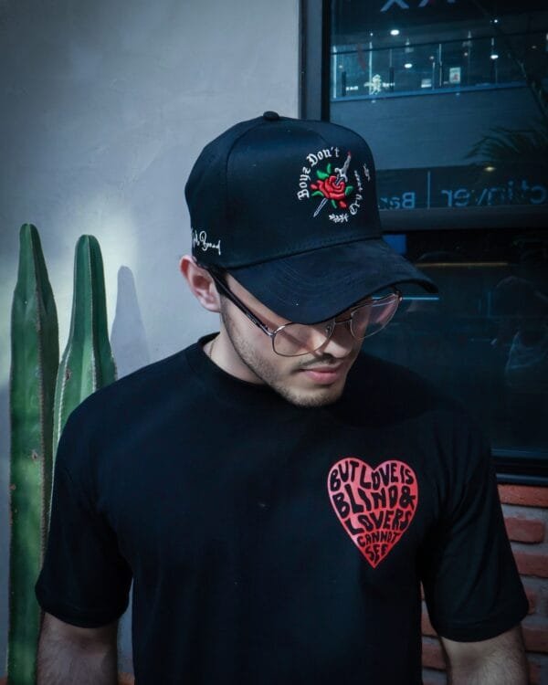 Hombre con lentes usando una gorra color negro